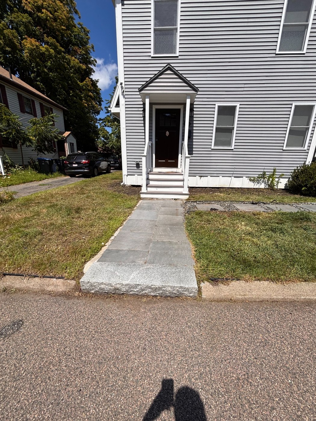 Front yard cleanup after cleanup: cleared lawn and visible walkway